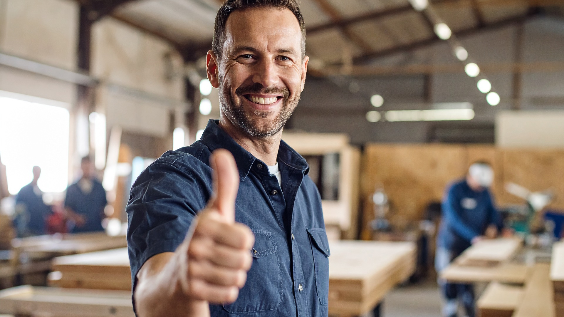 Junger Mann aus der Produktion hebt den Daumen